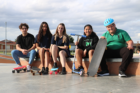 Group of teenagers sitting with skateboards